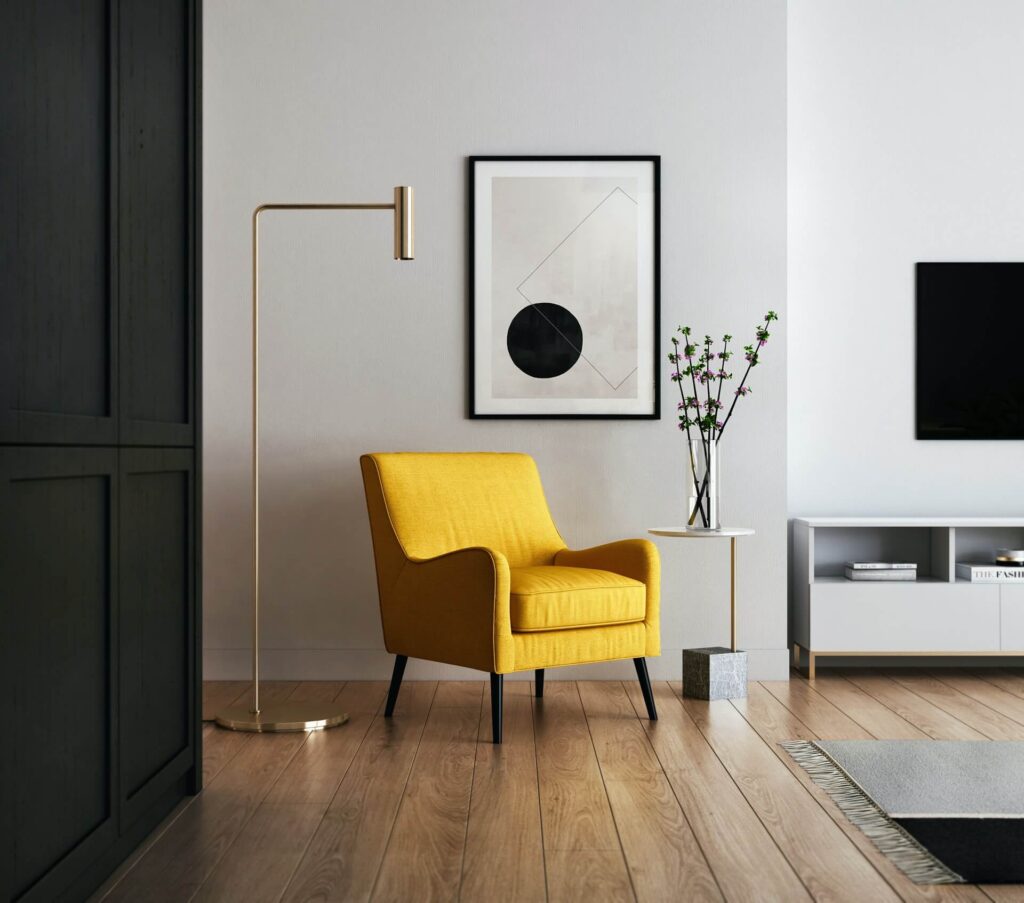 Designer yellow sofa chair is placed near the lamp in the room.